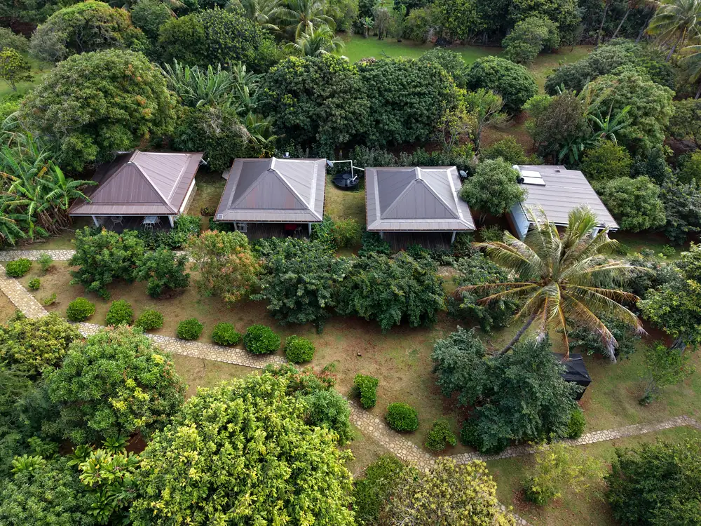 Vue aérienne des trois bungalows du Fare Manini dans leur jardin, à Rimatara